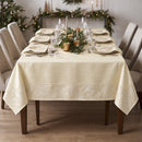 Tovaglia champagne in raso fiammato con cornice jacquard su tavola natalizia elegante