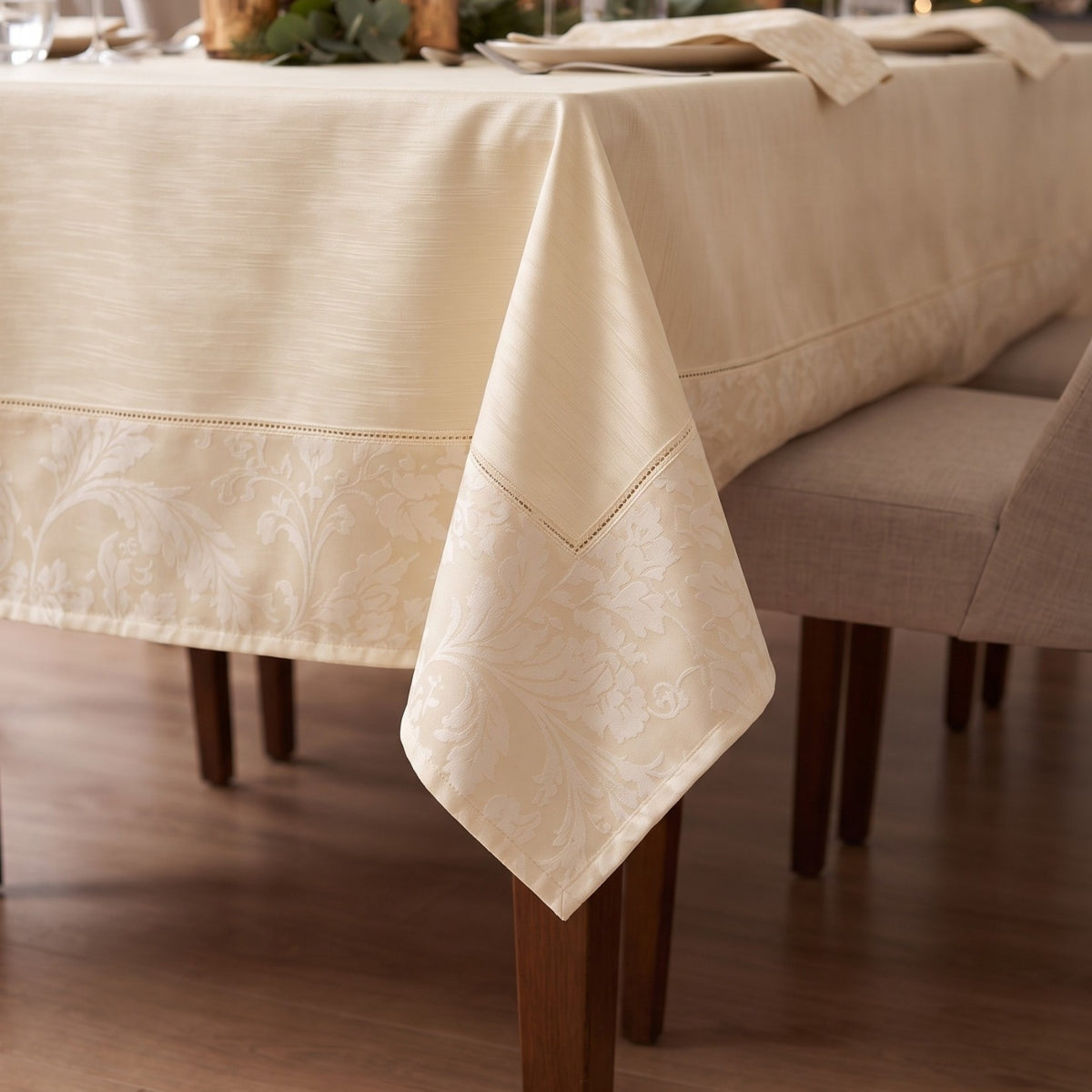 Dettaglio della tovaglia champagne in raso fiammato con cornice jacquard sulla caduta